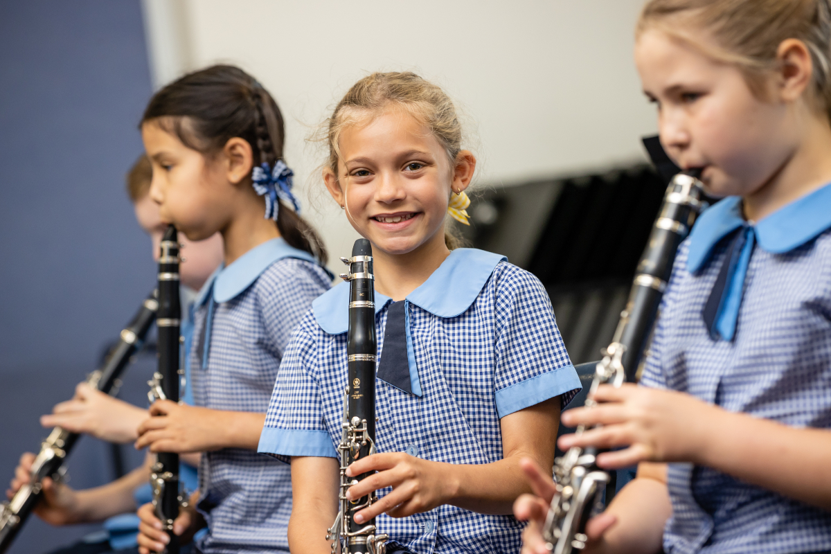 Students playing clarinets during a music lesson, highlighting instrumental learning, concentration and participation in the school music program